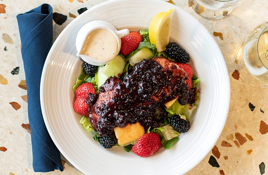 A 6-oz wild salmon fillet pan-roasted then glazed with our house-made local marionberry BBQ sauce. Served on a bed of chopped romaine with seasonal fresh fruit and a side of honey-mustard dressing.
